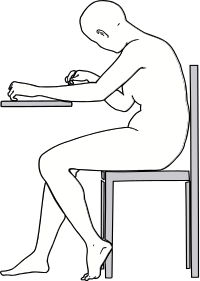 Side view of woman writing at table